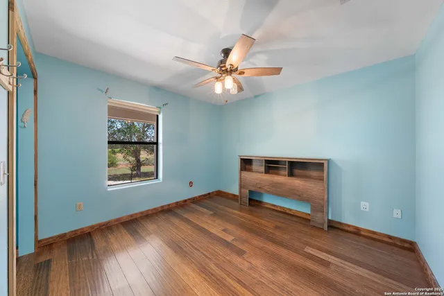 a view of workspace with hardwood floor and ceiling fan