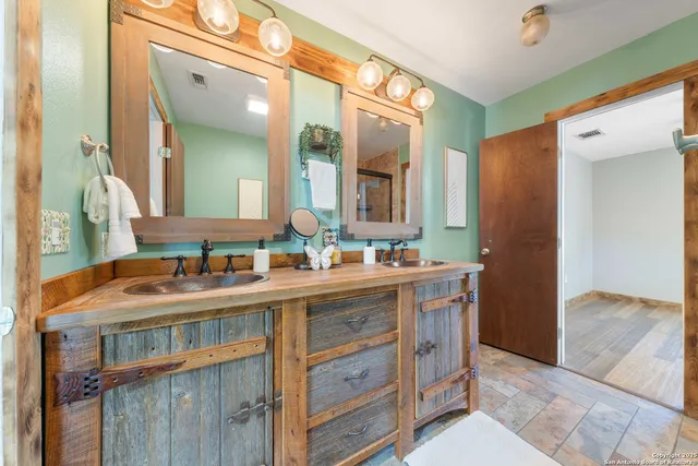 a bathroom with double vanity and a mirror