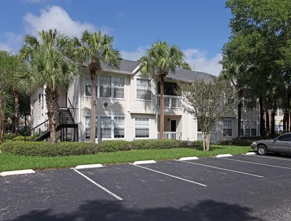 a front view of a house with a garden and trees
