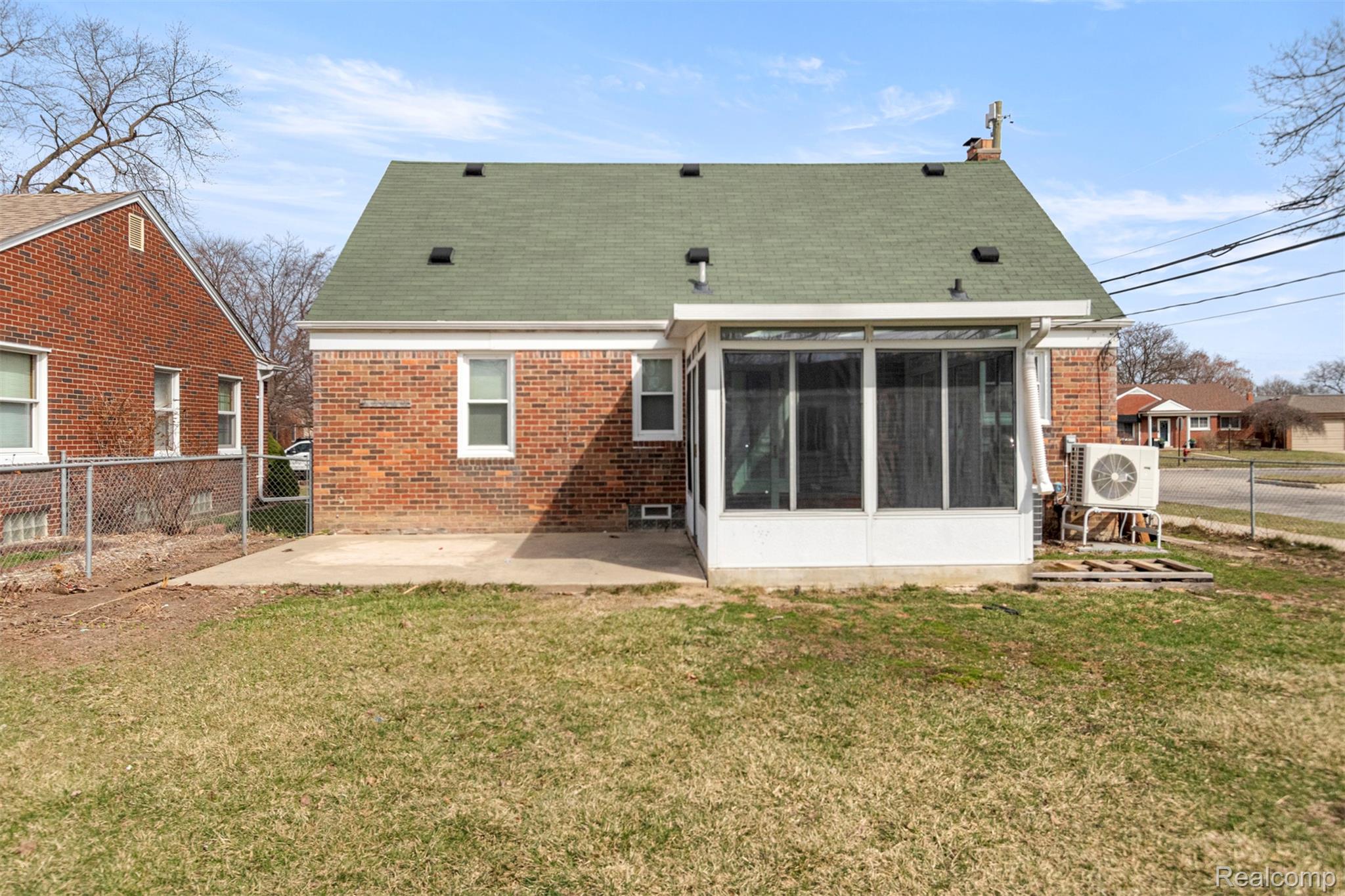 15705 Champaign Road Allen Park, MI 48101 - Photo 36 of 42 Rear view of house with a fenced backyard, a patio, brick siding, and a sunroom
