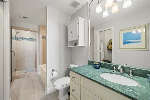 a bathroom with a granite countertop sink toilet and shower