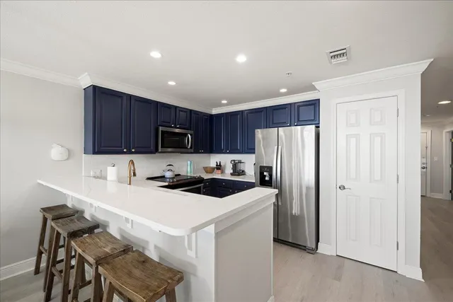 a kitchen with stainless steel appliances a stove a sink a refrigerator and cabinets