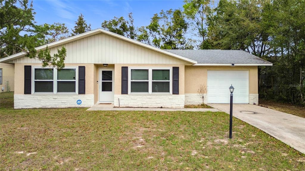 9040 Southeast 88th Street Ocala, FL 34472 - Photo 1 of 1 a house that has a tree in front of it