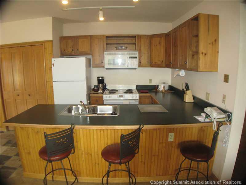 195 River Run Road, Unit 8053 Keystone, CO 80435 - Photo 6 of 16 a kitchen with a table chairs and a refrigerator