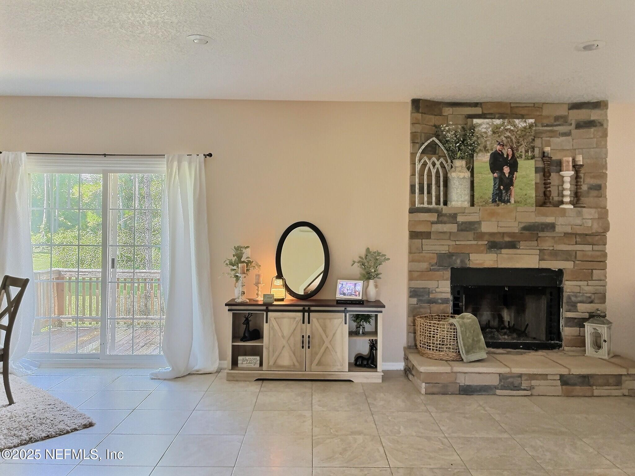 224 Crocus Lane Hawthorne, FL 32640 - Photo 15 of 58 a living room with furniture a fireplace and a floor to ceiling window
