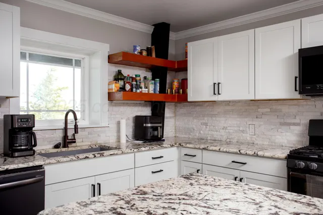 a kitchen with stainless steel appliances granite countertop a stove a sink and a microwave