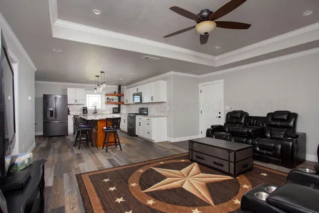 a living room with lots of furniture and kitchen view