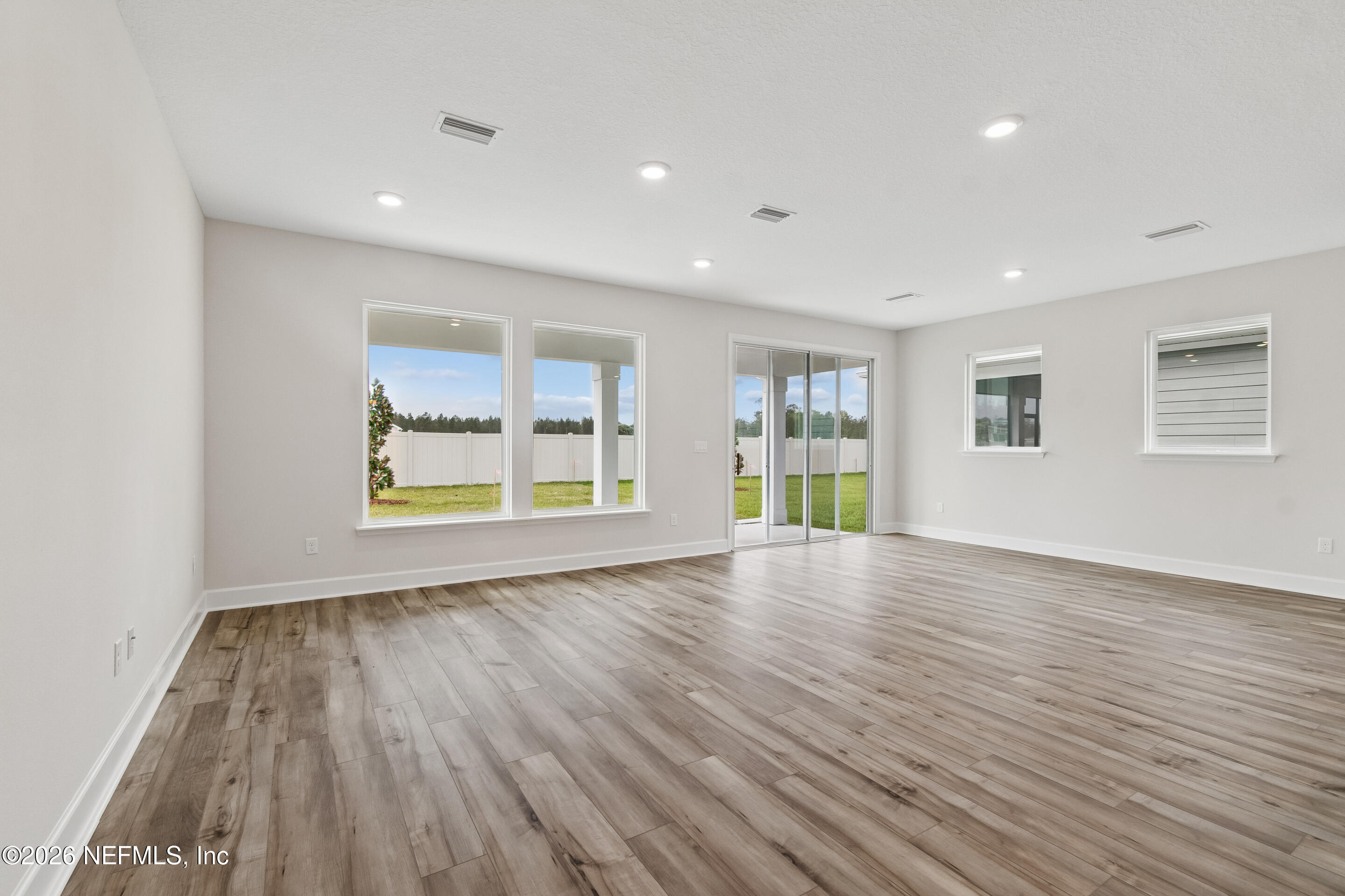 75751 Bayley Place Yulee, FL 32097 - Photo 11 of 28 a view of empty room with wooden floor and fan