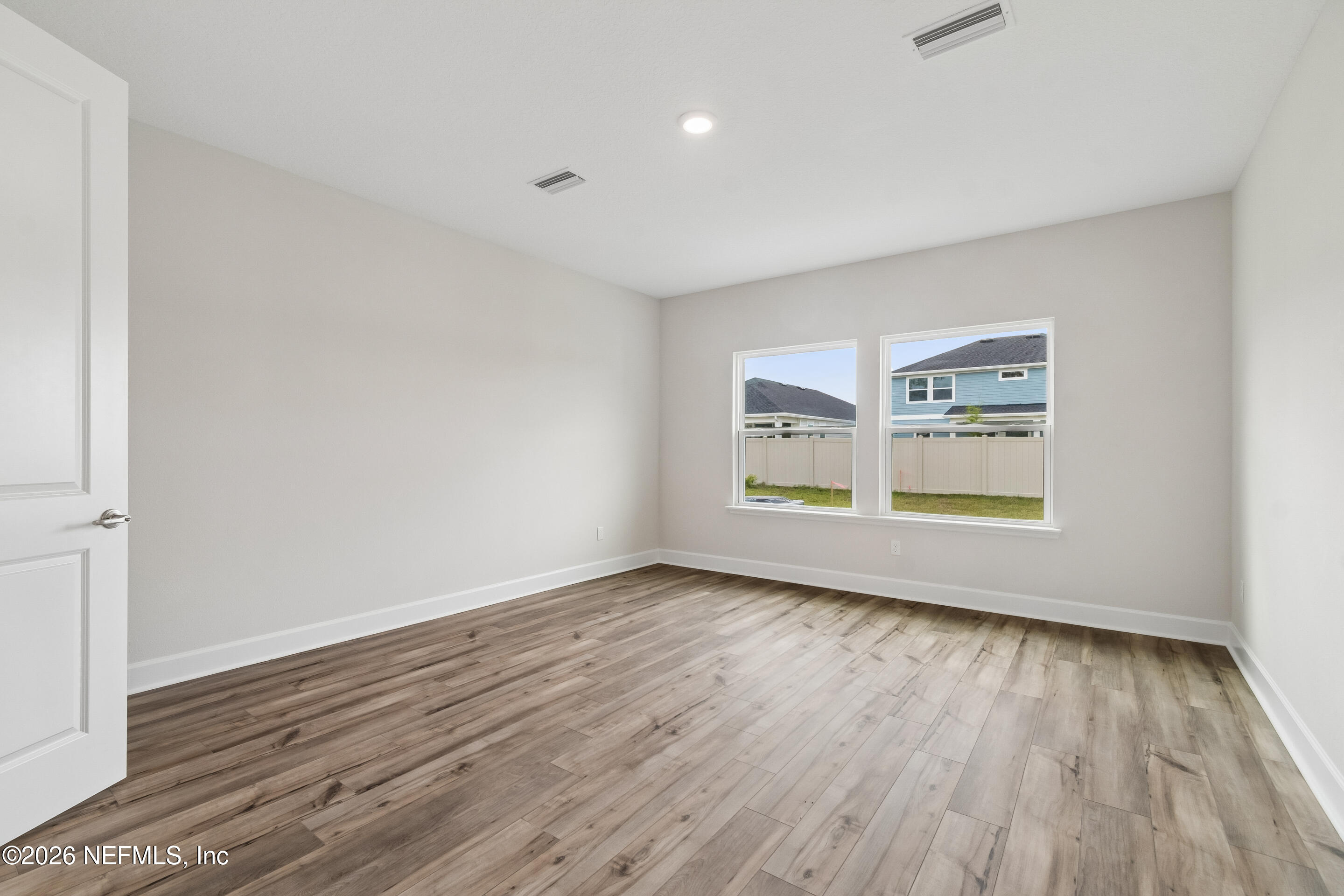 75751 Bayley Place Yulee, FL 32097 - Photo 13 of 28 an empty room with wooden floor and windows