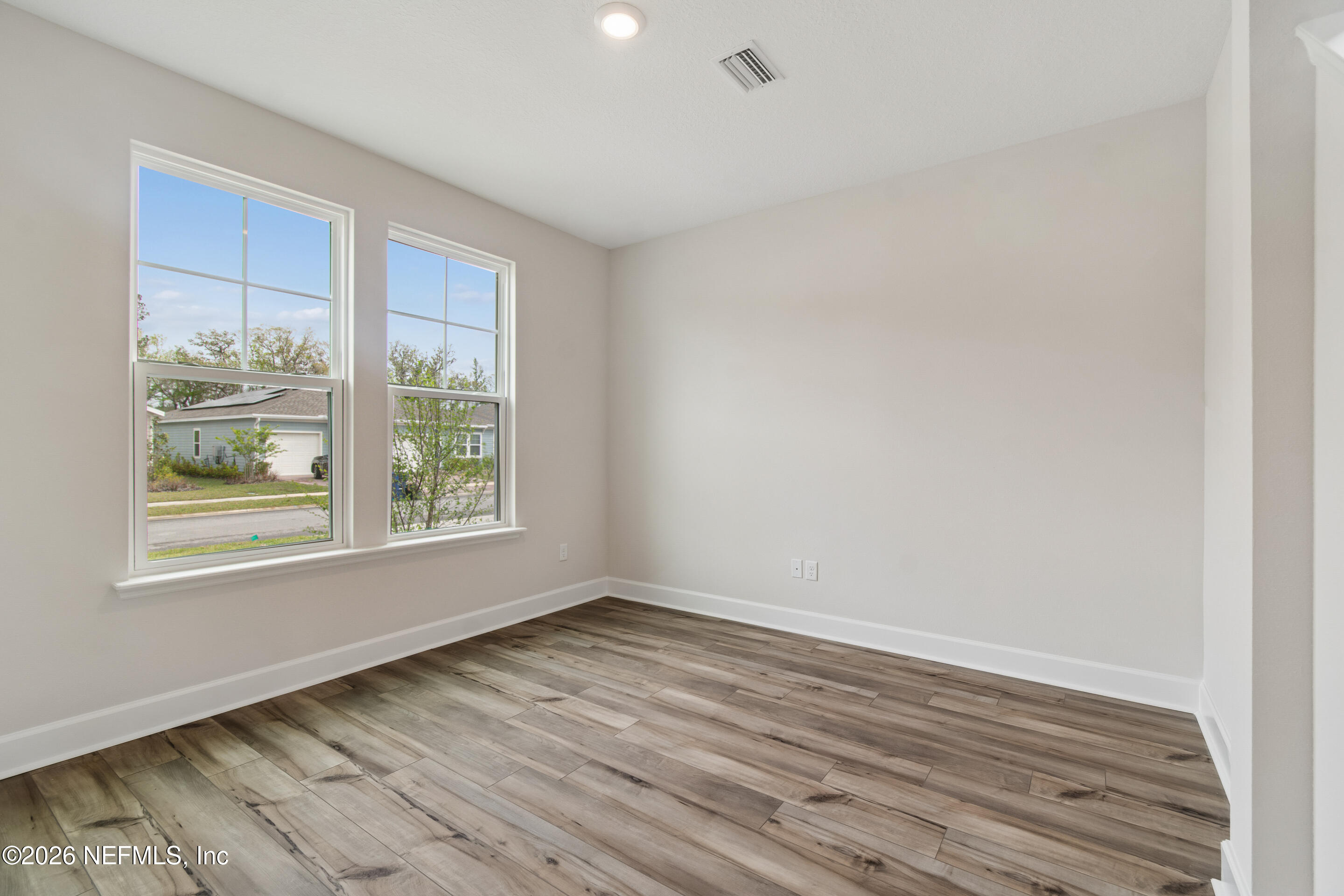 75751 Bayley Place Yulee, FL 32097 - Photo 17 of 28 an empty room with wooden floor and windows