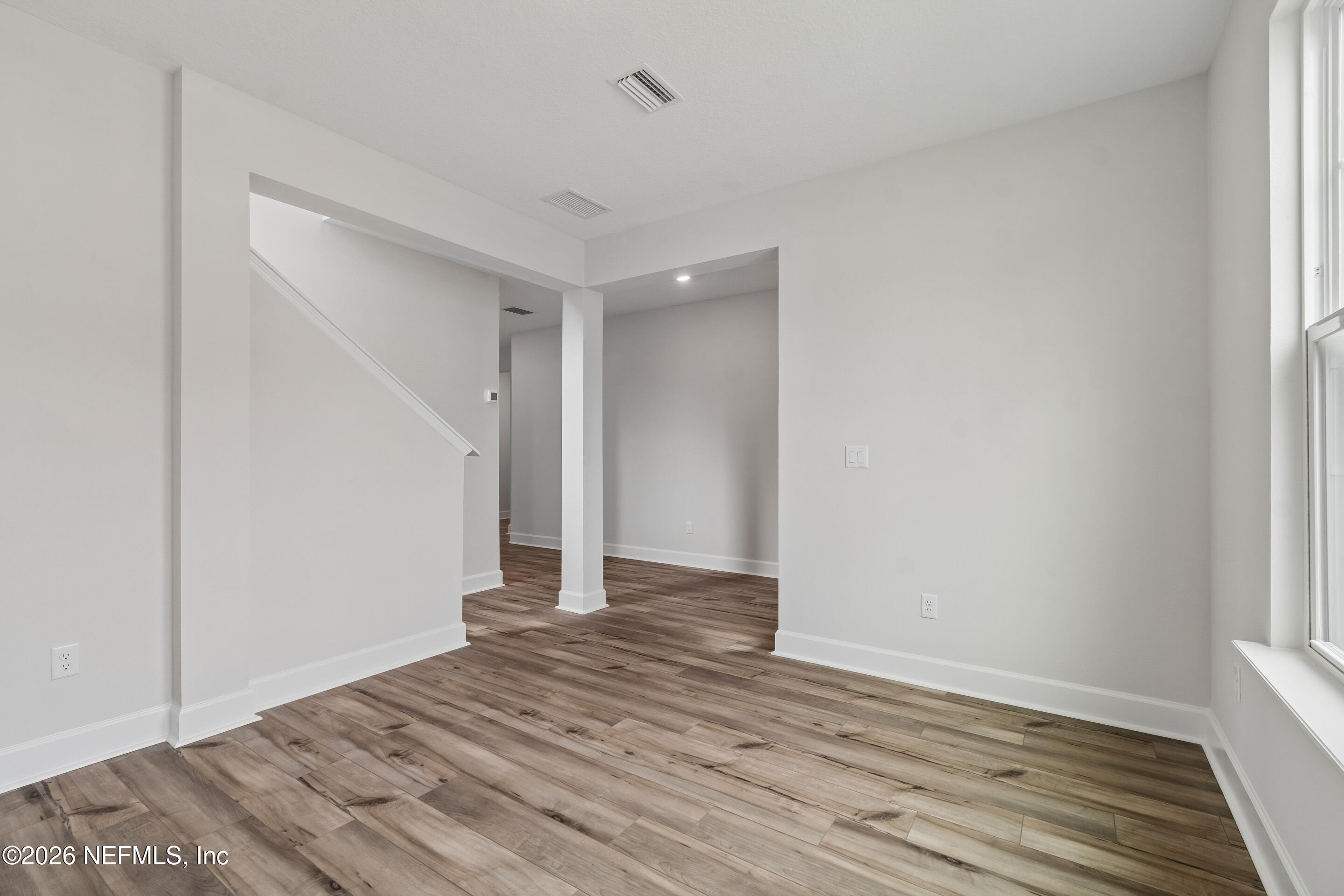 75751 Bayley Place Yulee, FL 32097 - Photo 19 of 28 a view of an empty room with wooden floor and closet