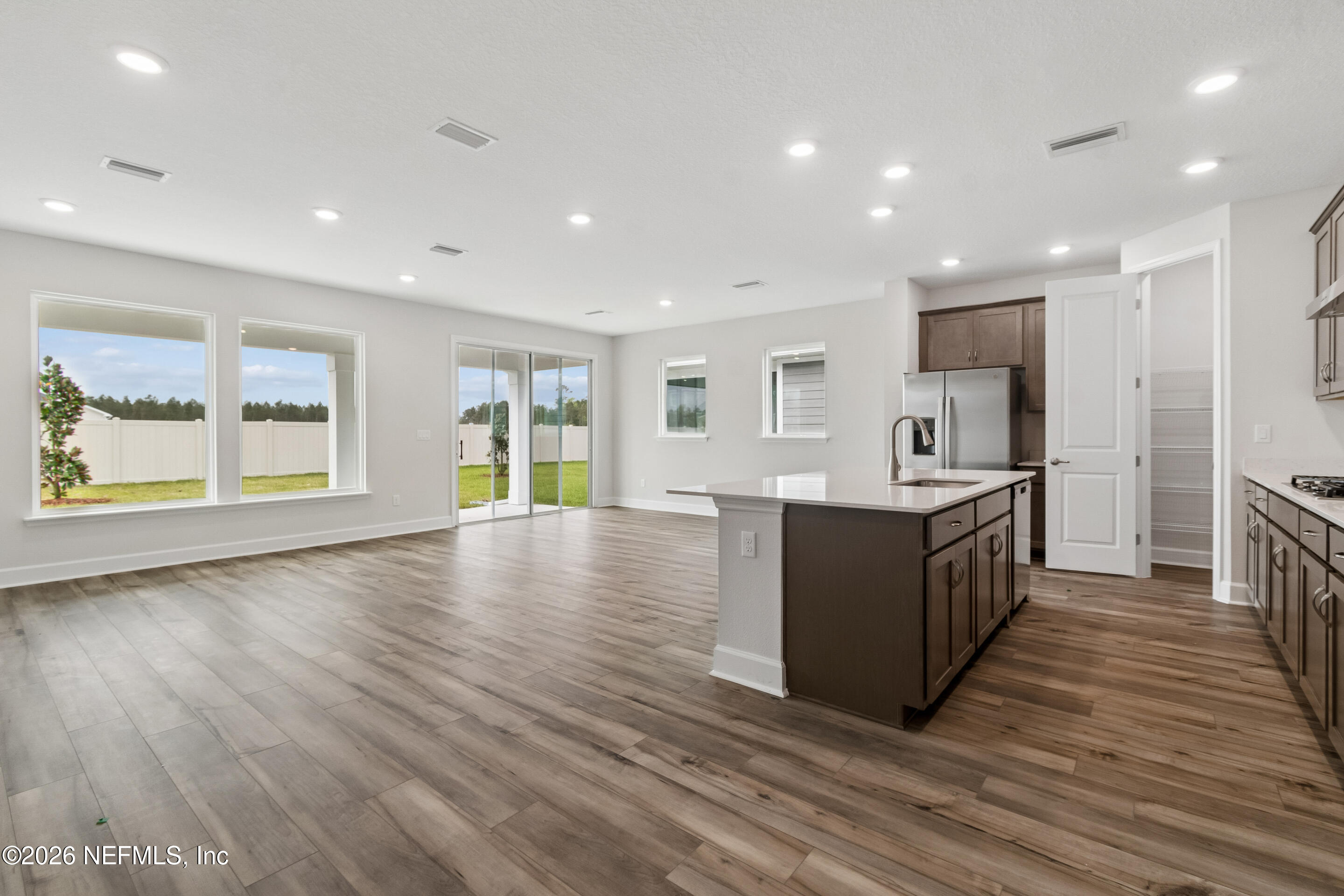 75751 Bayley Place Yulee, FL 32097 - Photo 3 of 28 a large kitchen with stainless steel appliances granite countertop a large counter top a wooden floors and a large window