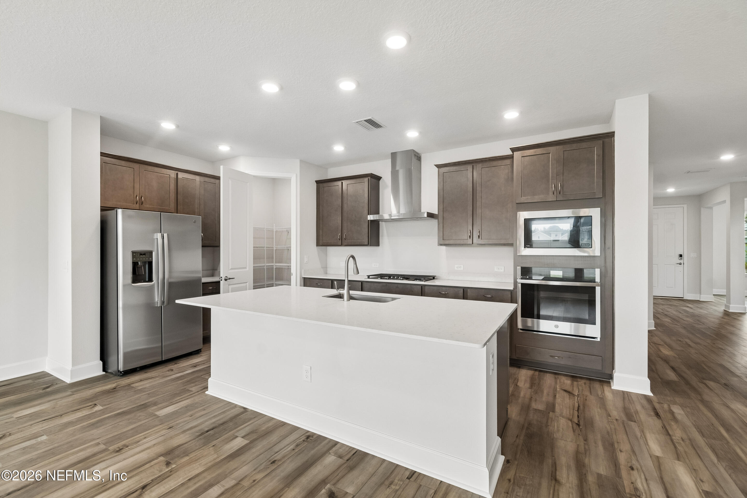 75751 Bayley Place Yulee, FL 32097 - Photo 7 of 28 a large kitchen with stainless steel appliances lots of counter top space cabinets and wooden floor