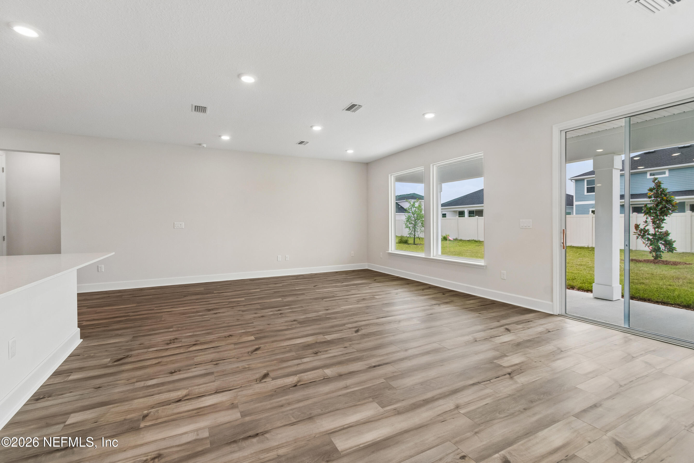 75751 Bayley Place Yulee, FL 32097 - Photo 10 of 28 a view of an empty room with wooden floor and a window