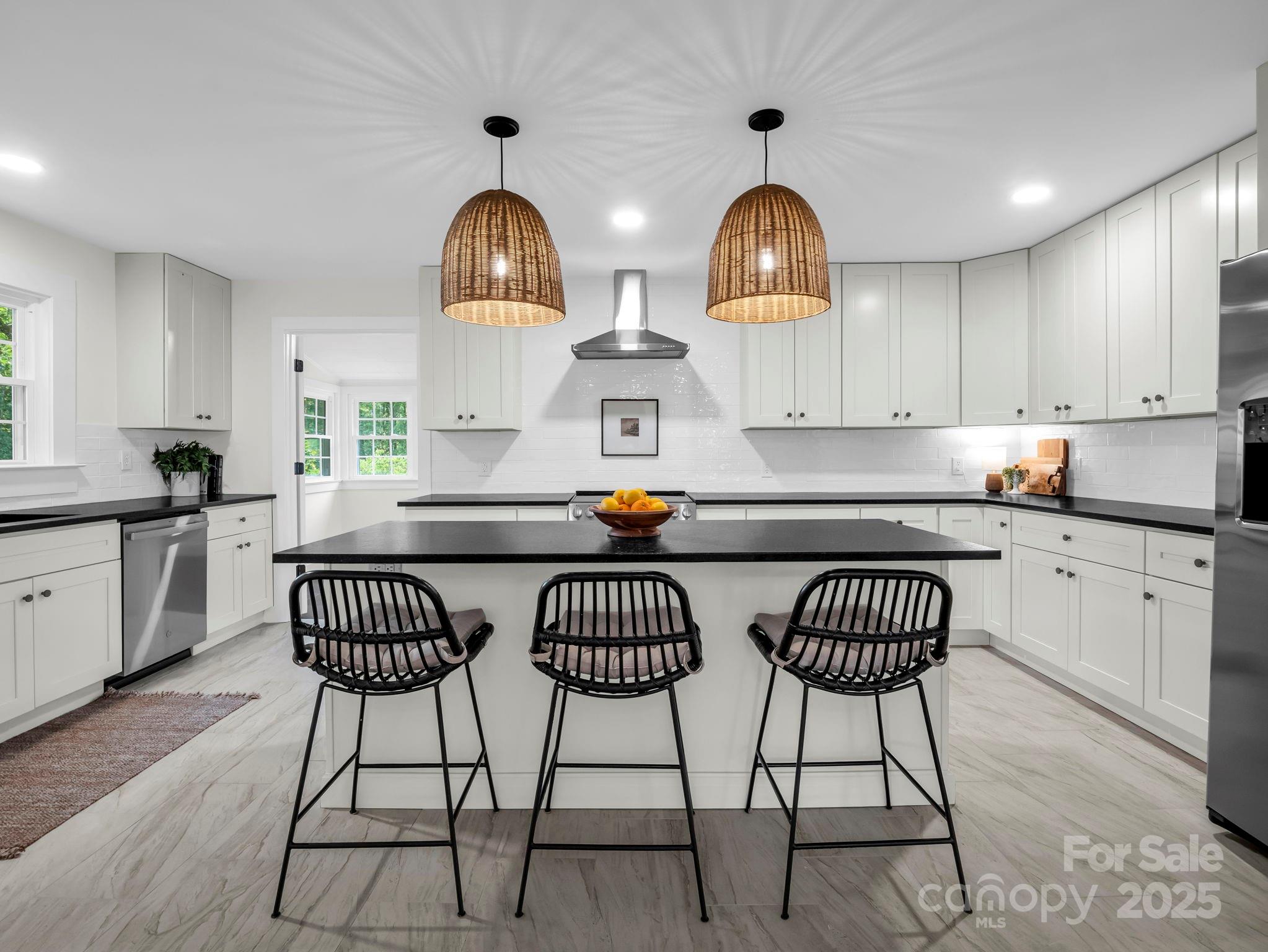 5990 South Nc 9 Highway Tryon, NC 28782 - Photo 17 of 42 a kitchen with a sink a stove and chairs with wooden floor
