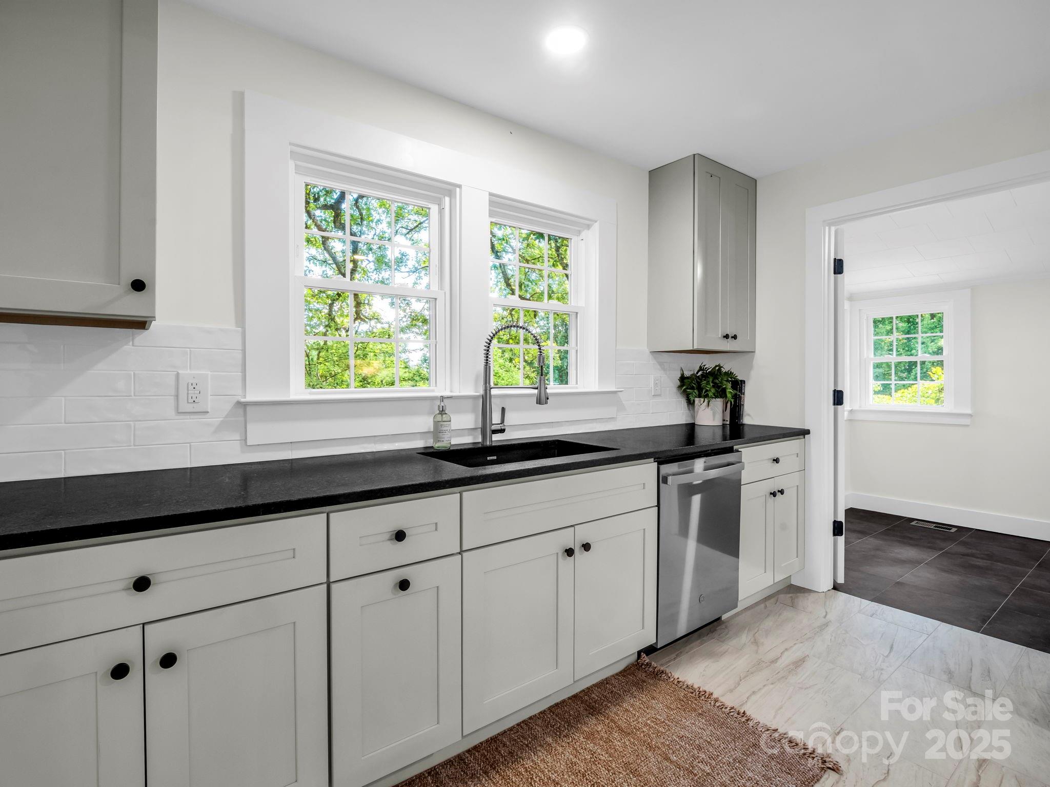 5990 South Nc 9 Highway Tryon, NC 28782 - Photo 18 of 42 a kitchen with granite countertop white cabinets and window