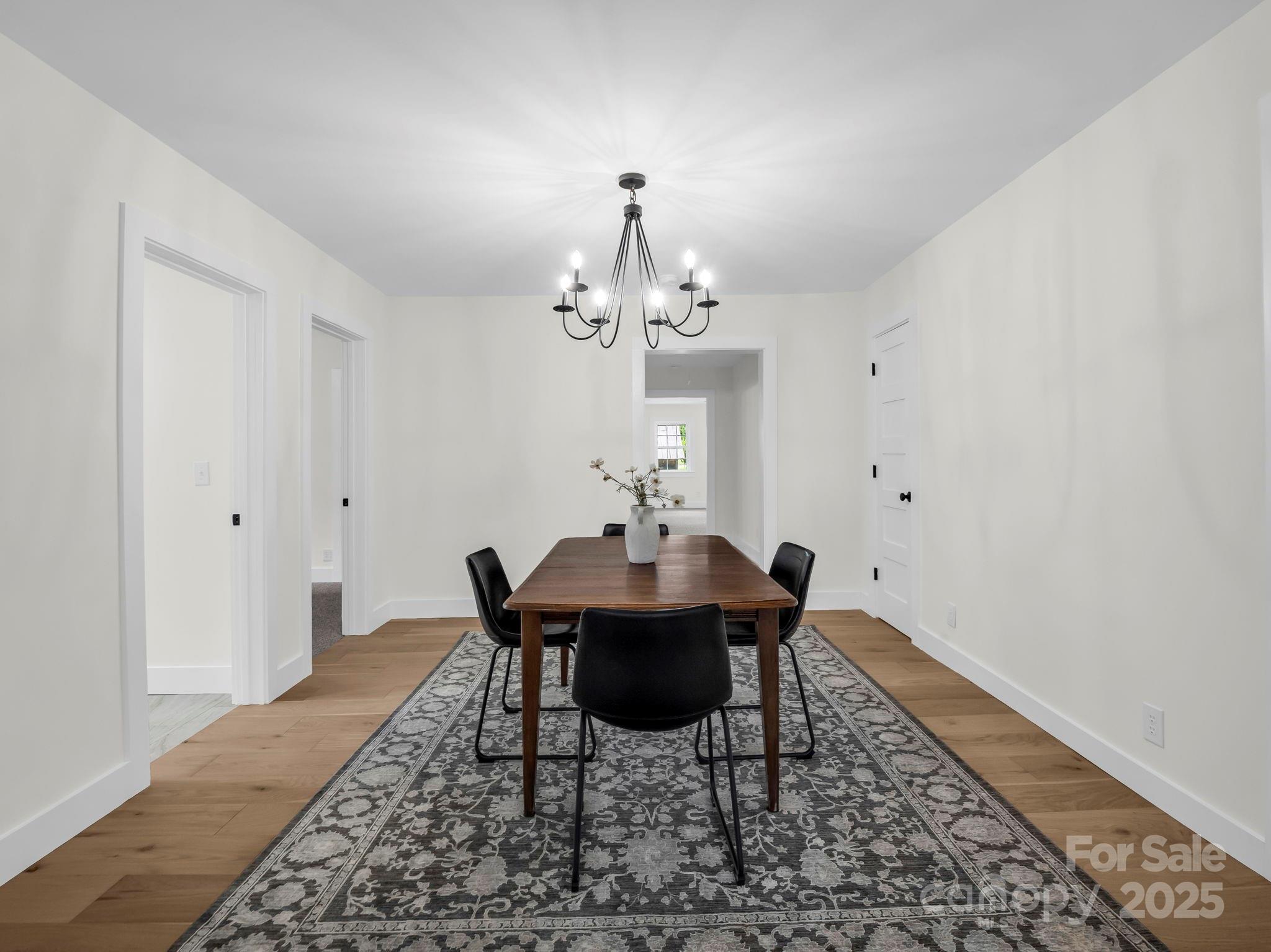 5990 South Nc 9 Highway Tryon, NC 28782 - Photo 30 of 42 a dining room with wooden floor and chandelier