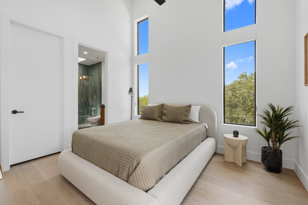 1712 Saracen Road Austin, TX 78733 - Photo 14 of 20 a bedroom with a large bed and a potted plant