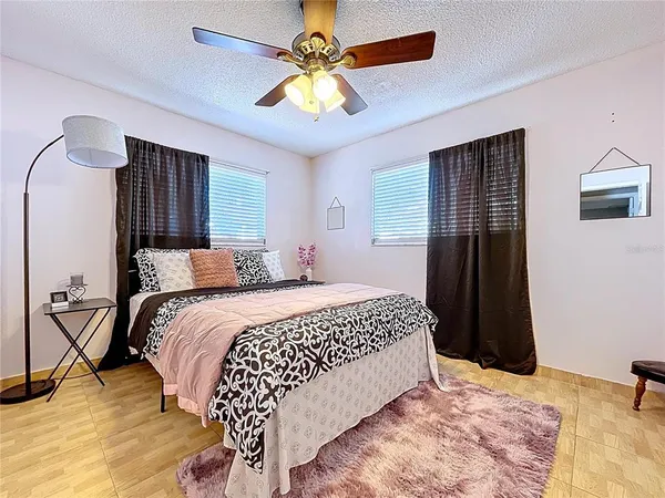 a bedroom with a bed and a ceiling fan
