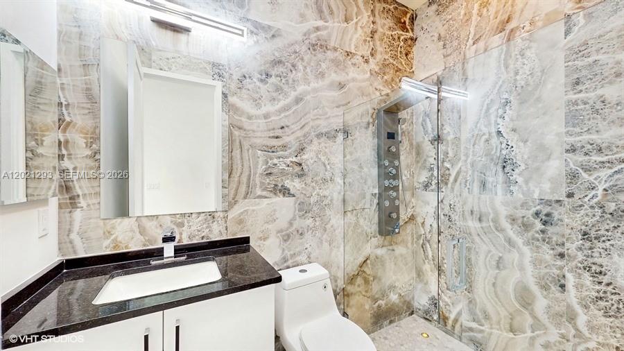 8350 Royal County Down Road Boca Raton, FL 33434 - Photo 17 of 52 a bathroom with a granite countertop sink and a mirror