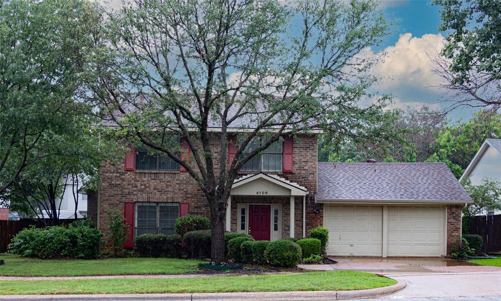 a front view of a house with a garden and trees