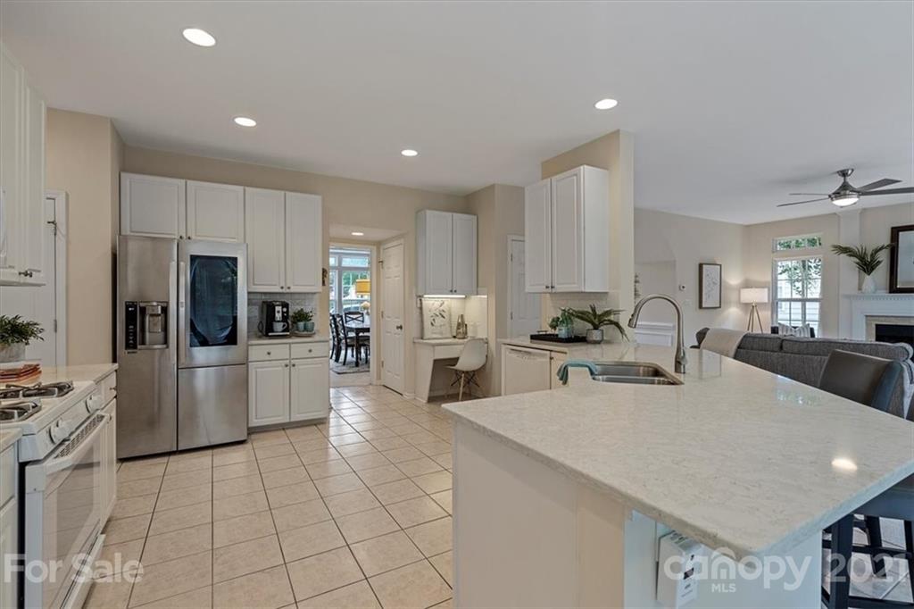 6616 Elfreda Road Charlotte, NC 28270 - Photo 15 of 37 a large white kitchen with cabinets a sink a counter and stainless steel appliances