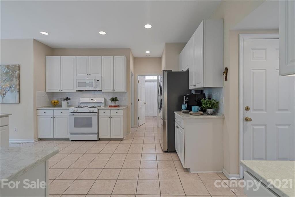 6616 Elfreda Road Charlotte, NC 28270 - Photo 16 of 37 a kitchen with white cabinets and white appliances