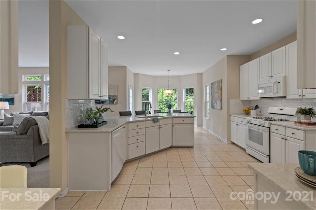 6616 Elfreda Road Charlotte, NC 28270 - Photo 17 of 37 a large kitchen with kitchen island granite countertop a sink and white cabinets