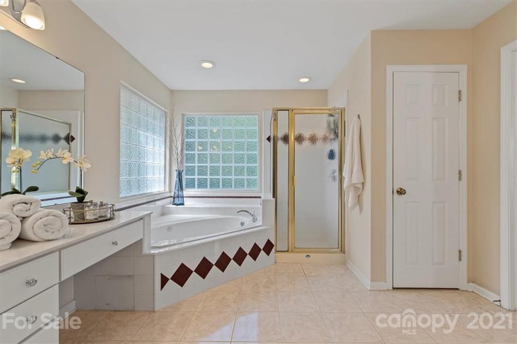 6616 Elfreda Road Charlotte, NC 28270 - Photo 31 of 37 a spacious bathroom with a tub sink and mirror