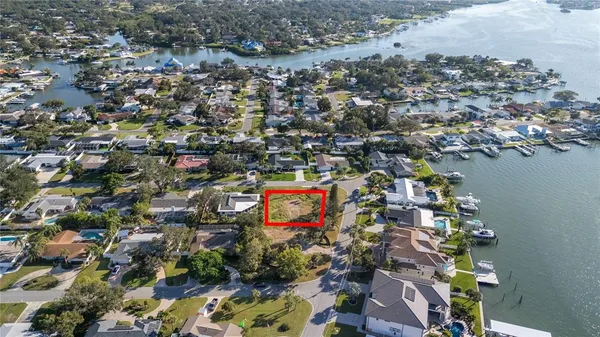 an aerial view of ocean and residential houses with outdoor space