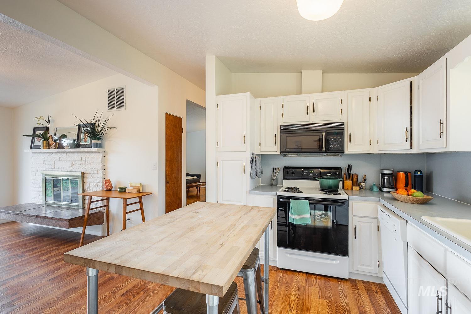 6403 Colonial Drive Boise, ID 83709 - Photo 18 of 42 Kitchen featuring electric stove, light countertops, vaulted ceiling, white cabinetry, and black microwave