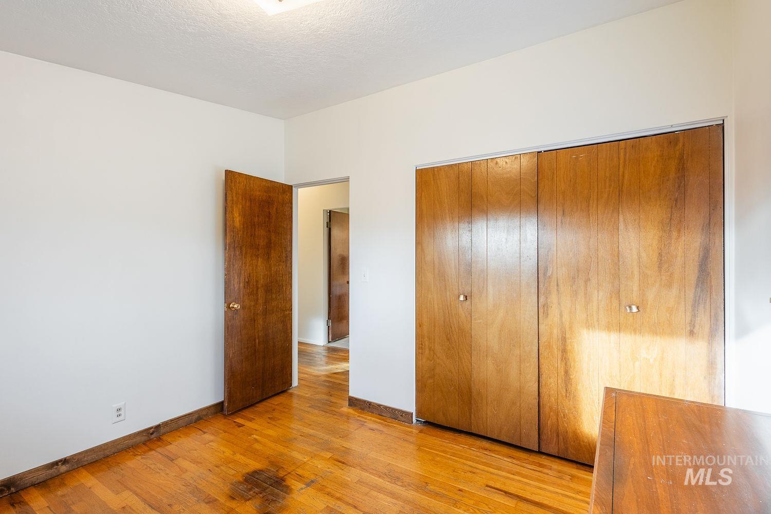 6403 Colonial Drive Boise, ID 83709 - Photo 22 of 42 Unfurnished bedroom with light wood-style flooring, a closet, and a textured ceiling
