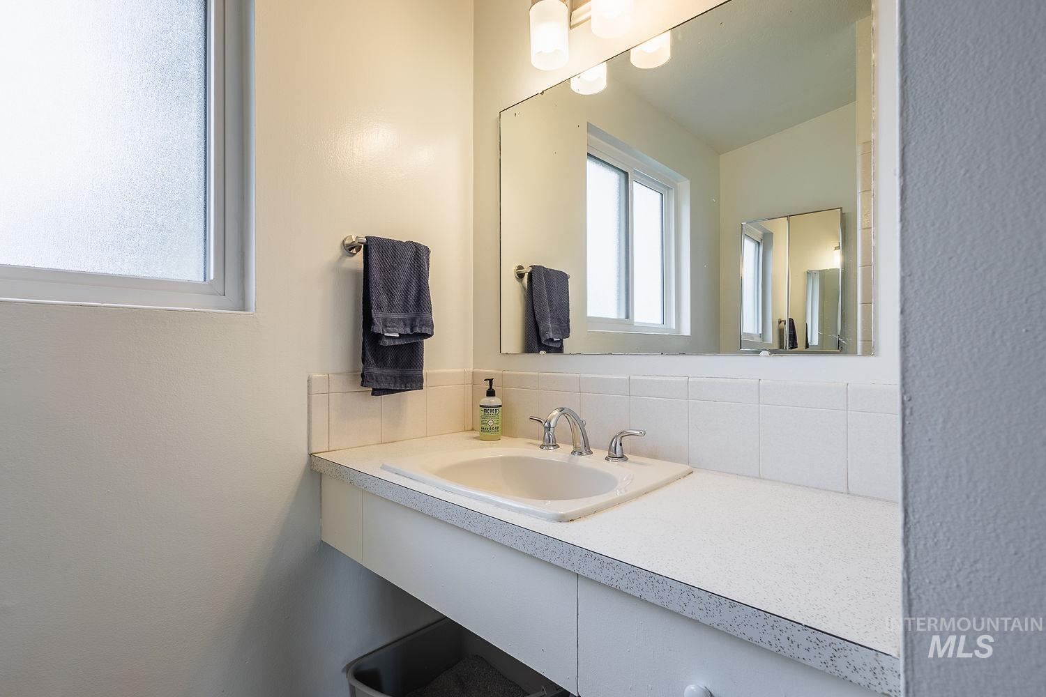 6403 Colonial Drive Boise, ID 83709 - Photo 23 of 42 Bathroom with vanity, decorative backsplash, and a textured wall