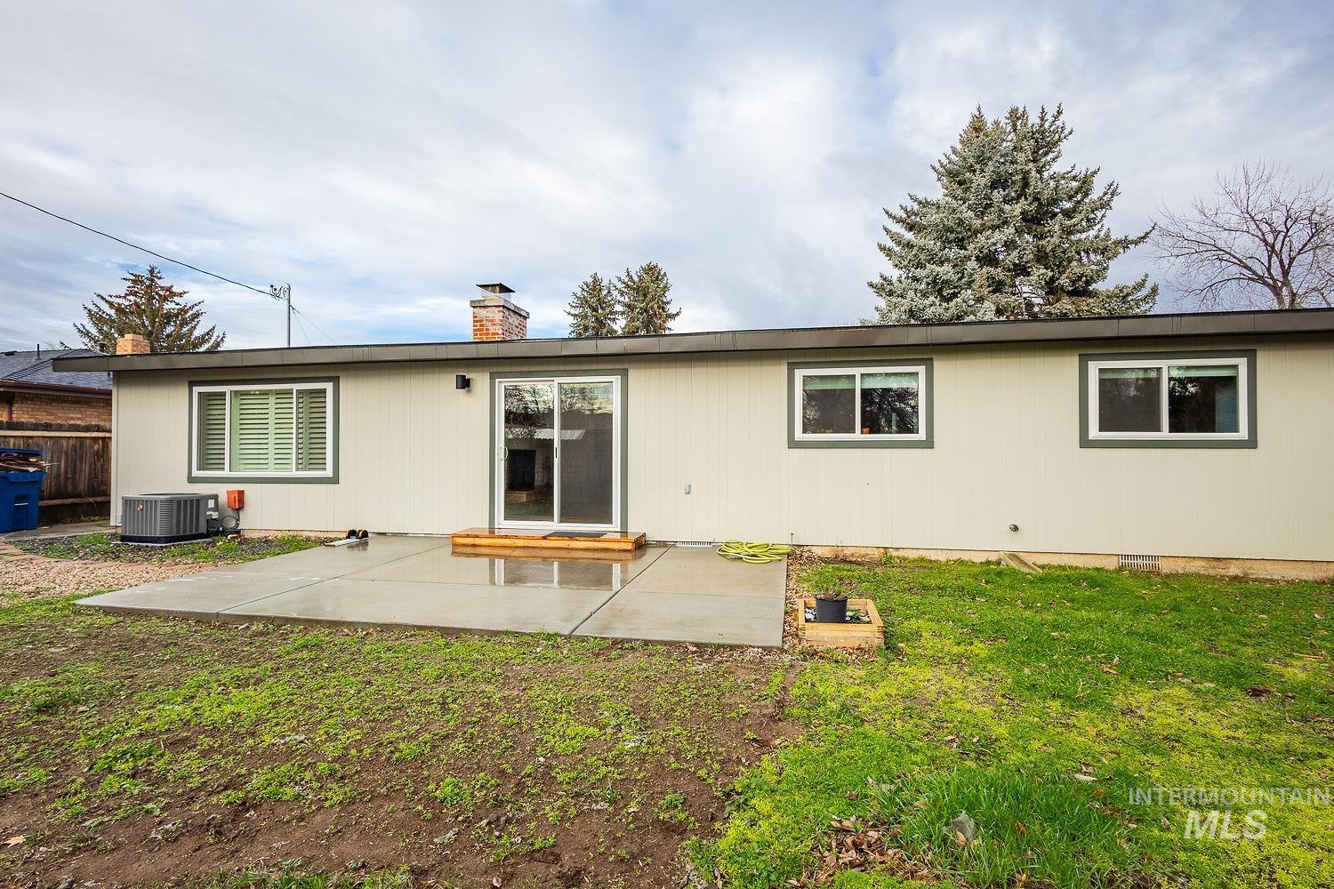6403 Colonial Drive Boise, ID 83709 - Photo 34 of 42 Back of house featuring a patio, a lawn, and a chimney
