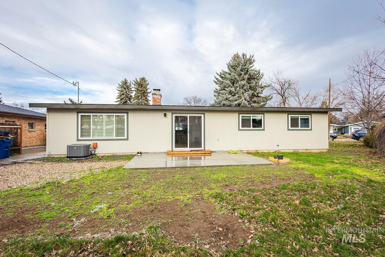 6403 Colonial Drive Boise, ID 83709 - Photo 35 of 42 Rear view of house featuring a patio area, a lawn, and a chimney