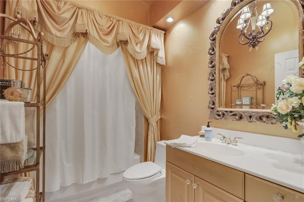 10801 Crooked River Road, Unit 203 Estero, FL 34135 - Photo 18 of 27 a bathroom with a sink a toilet and shower curtain