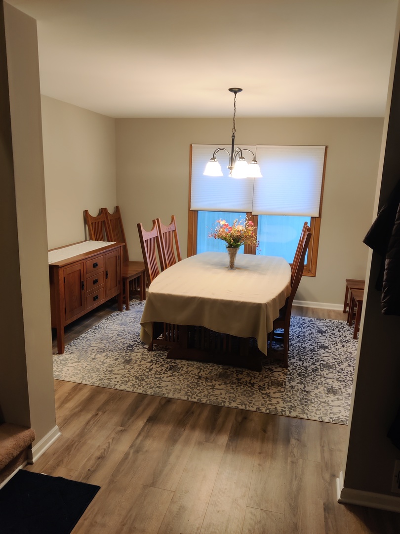 1681 Boulder Ridge Drive Bolingbrook, IL 60490 - Photo 13 of 17 a spacious bedroom with a bed a chandelier and a dresser in it