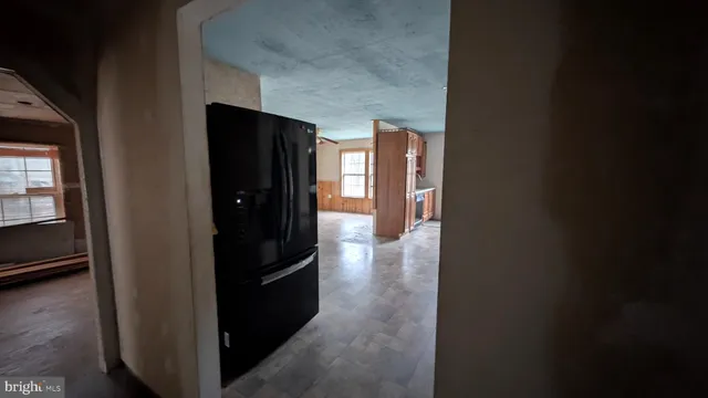 a view of a hallway with wooden floor and a cabinet