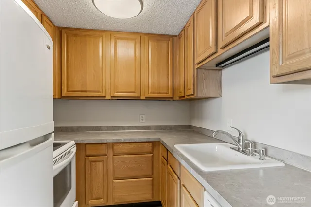 a kitchen with stainless steel appliances granite countertop a sink a stove and cabinets