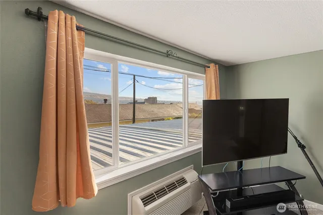 a view of a room with wooden floor and windows