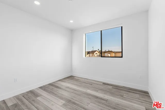 an empty room with wooden floor & closet area