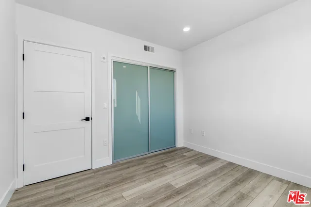 a view of a room with wooden floor and white walls