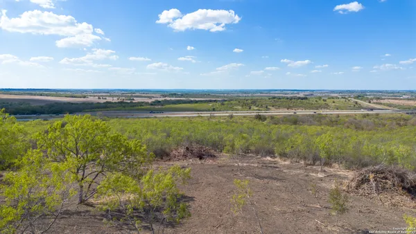 a view of a dry yard and mountain in the background