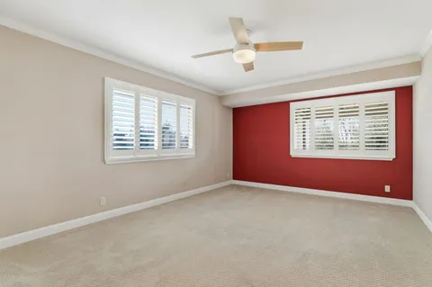 an empty room with fan and windows