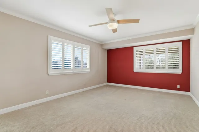 an empty room with fan and windows
