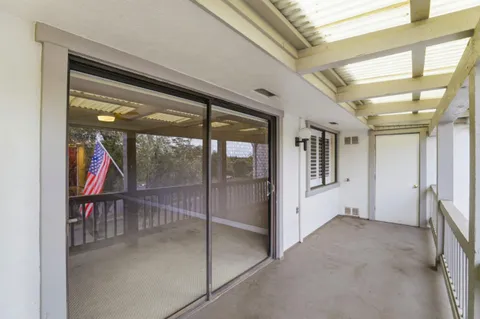 a front view of a house with a yard and potted plants
