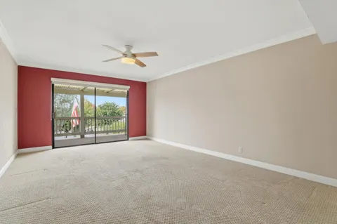 an empty room with windows and ceiling fan
