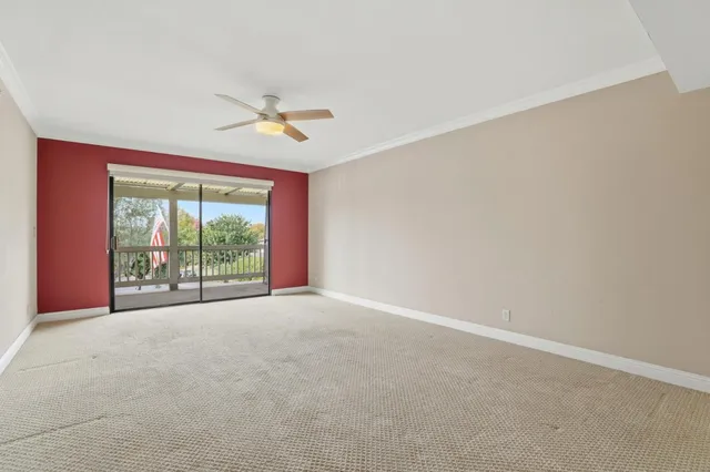 an empty room with windows and ceiling fan