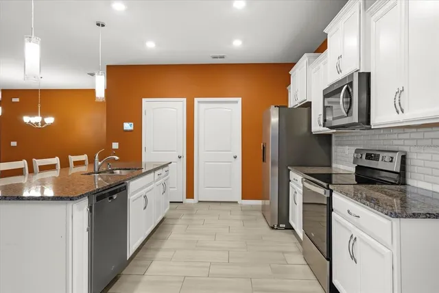 a kitchen with granite countertop a sink and cabinets