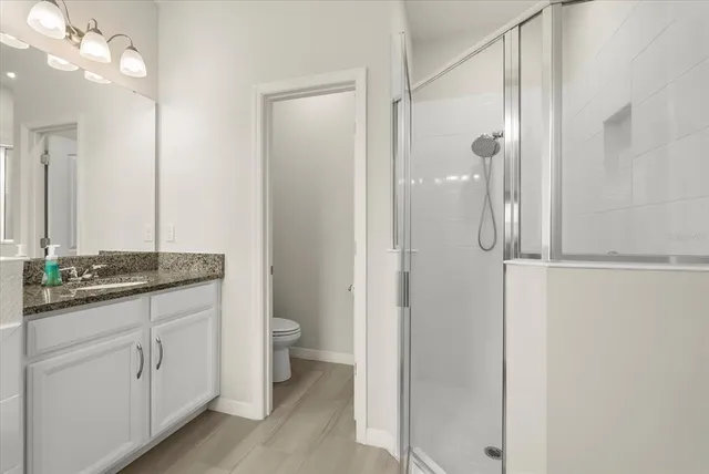 a bathroom with a granite countertop sink a large mirror and a bathtub